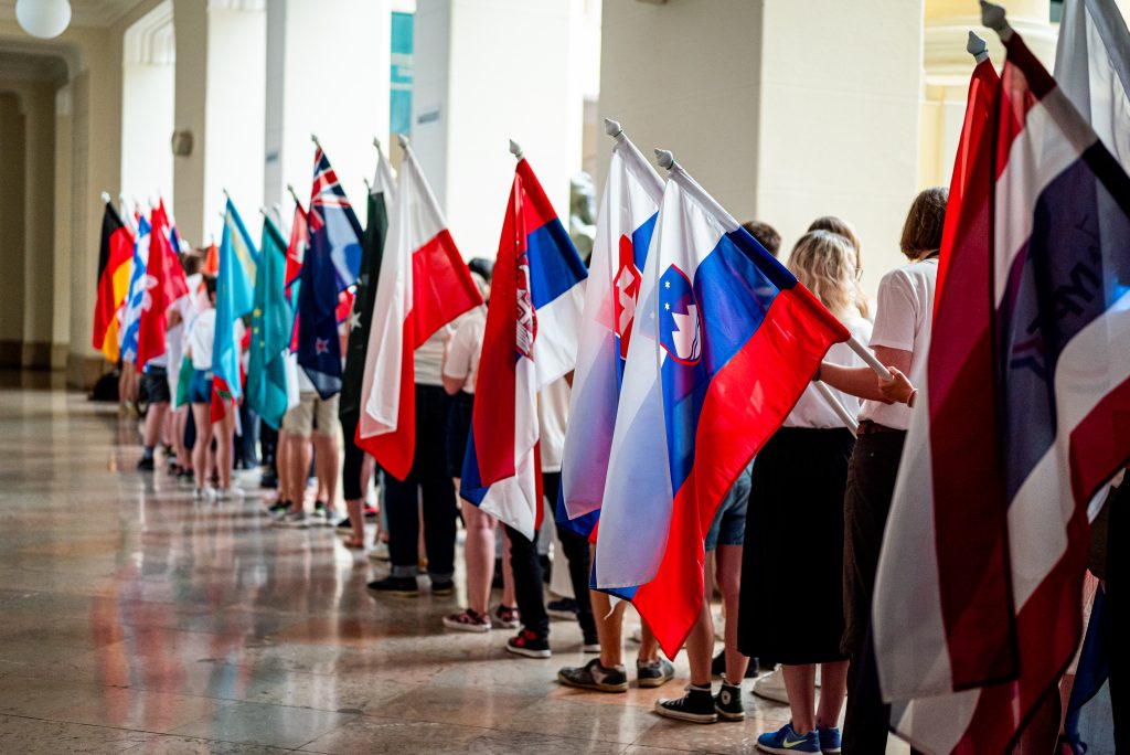 Line of IYPT student flag bearers with their national flags waiting to parade in the opening ceremony in IYPT Hungary 2024.