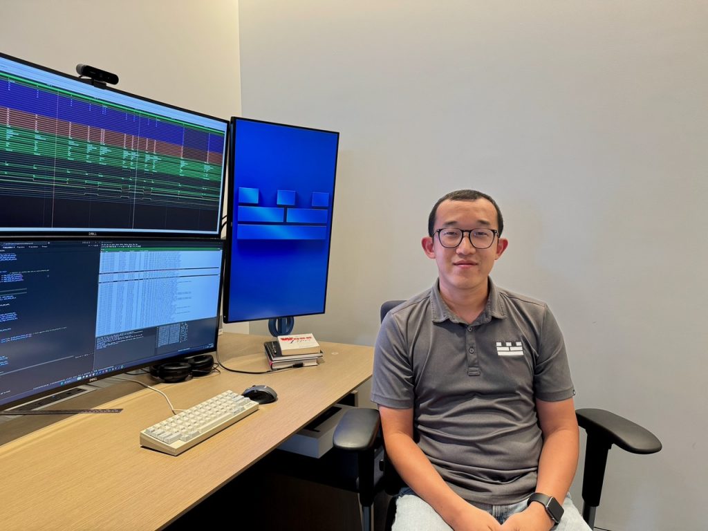 Jed Bien, NZYPT Alumni, at work for Citadel Securities with tree very large monitors on his desk.