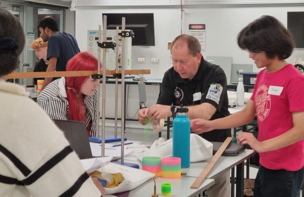 Gavin working with students on a slinky spring experiment